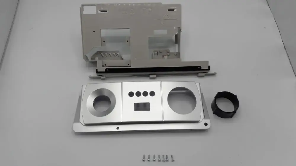 Vorderteil eines Schaltfeldes von Remeha, bestehend aus mehreren Metall- und Kunststoffteilen, darunter eine Grundplatte mit Ausschnitten und Bedienelementen.